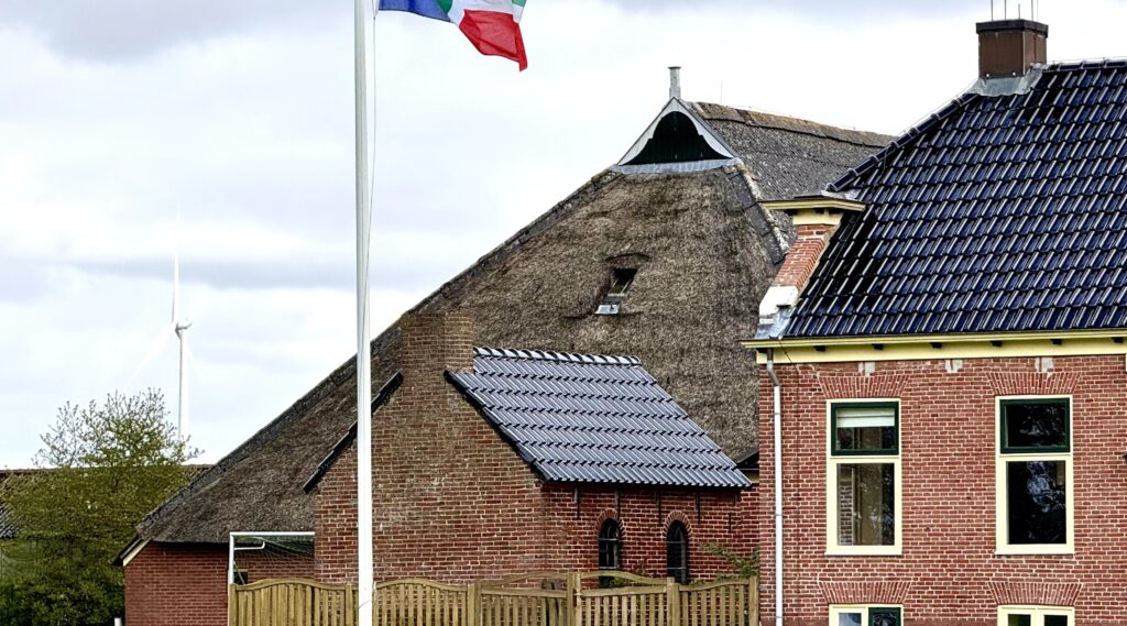 Groningse vlag die wappert bij een boerderij