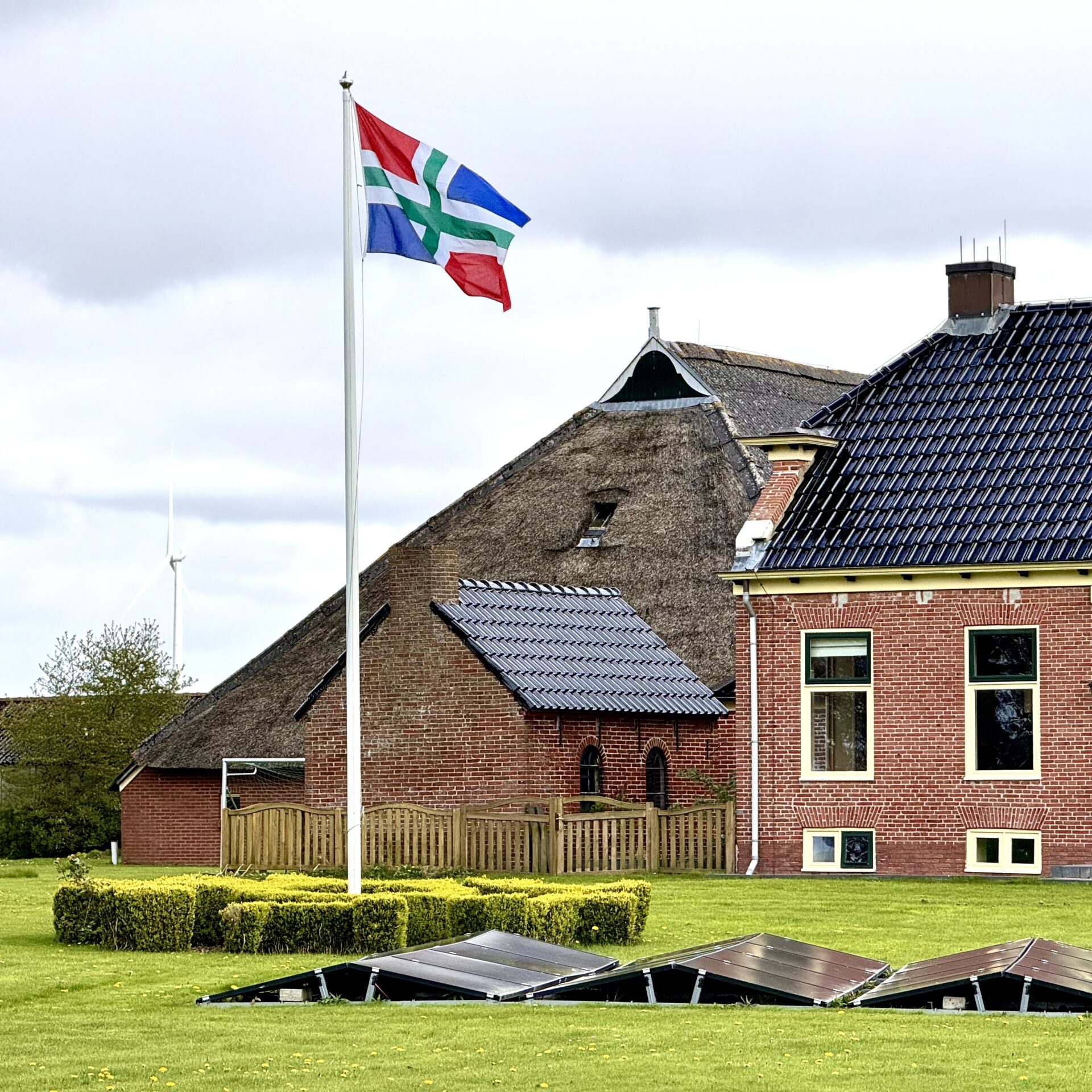 Groningse vlag die wappert bij een boerderij